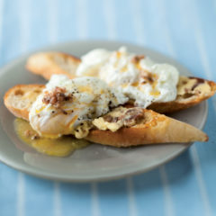 Anchovy-buttered crostini with poached eggs