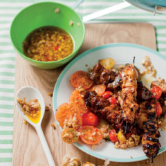 Kebabs with tomato salad and roasted garlic and peanut dressing