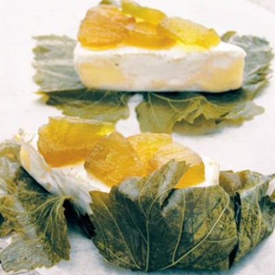 Brie and watermelon preserve wrapped in vine leaves