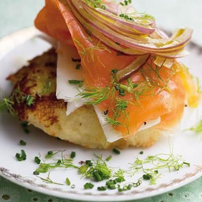 Crispy potato cakes draped with salmon and red onion slivers