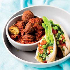 Falafel in spicy tomato sauce with salad-stuffed pitas
