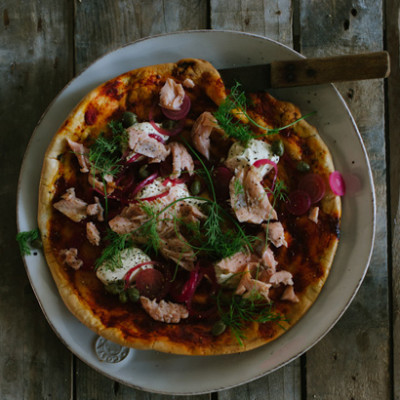 Flaked trout and creme fraiche pizza with capers and pickled red onions