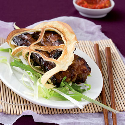 Lace pancakes stuffed with sticky soy ribs served with spring-onion curls