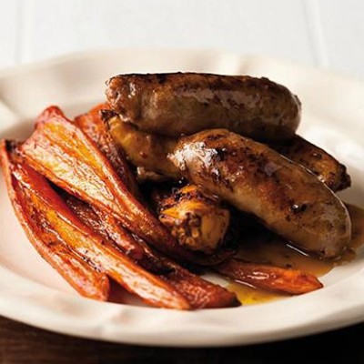 Maple syrup-roasted carrots and chilli potato wedges with pork bangers