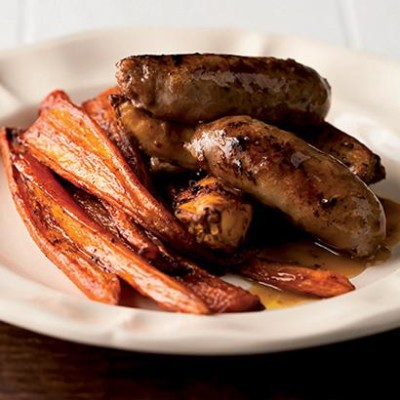 Maple syrup-roasted carrots and chilli wedges with pork bangers
