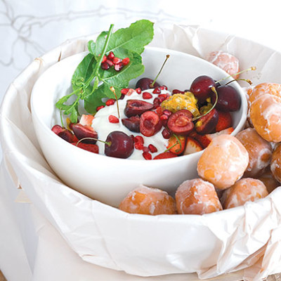 Piles of frosted mini doughnuts with fresh berries and creamy lemon-curd yoghurt