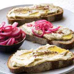 Rye slices topped with pickled red onions and hummus