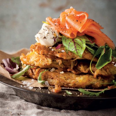 Potato rostis topped with salad greens, salmon and crème fraîche