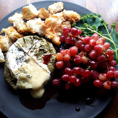Camembert roasted in vine leaves with verjuice-poached grapes