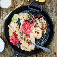 Whole braaied yellowtail in newspaper with chipotle mayonnaise and red onion pickle