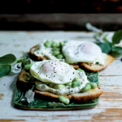 Wafer crostini toasts topped with smooth chive cheese, broad beans and soft-poached eggs