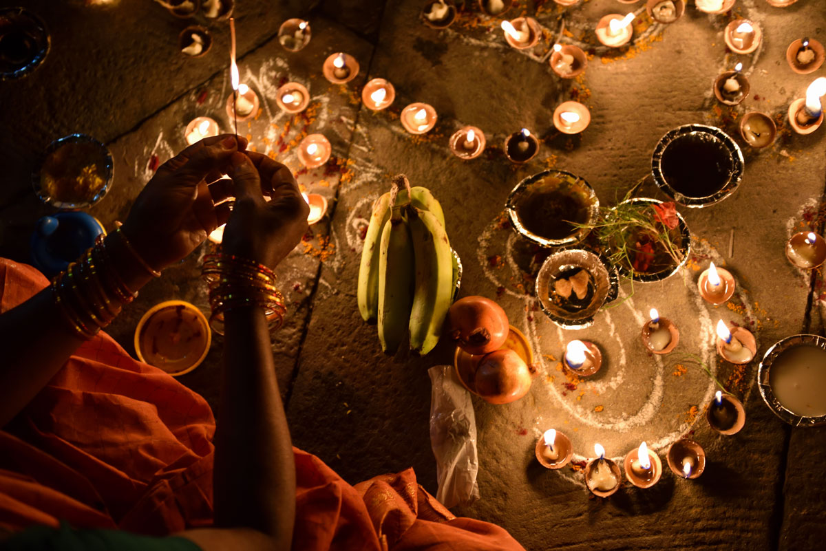 Close up hand lighing Diwali lamps