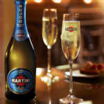Bottle of Martini 0.0 with filled champagne glasses