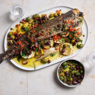 Whole lemon stuffed hake with olive and caper sauce