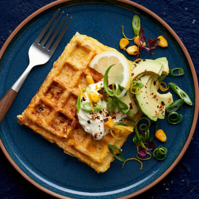 Corn and cheese waffles with avocado, spring onion and crème fraiche