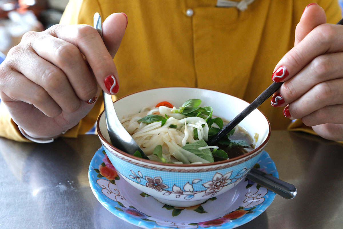 Woman eating traditional vietmamese soup Pho. Tan Chau. Vietnam for Getty